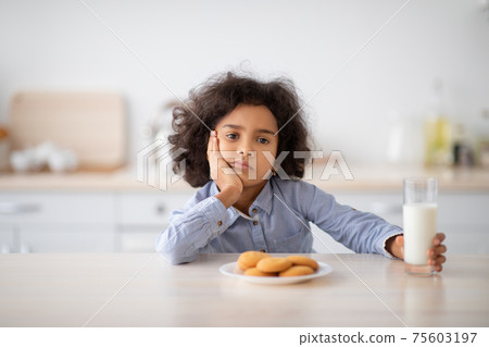 Portrait Of Sad Little Black Girl Holding Glass Of Milk Portrait Of Sad Little Black Girl Holding Glass Of Milk 75603197