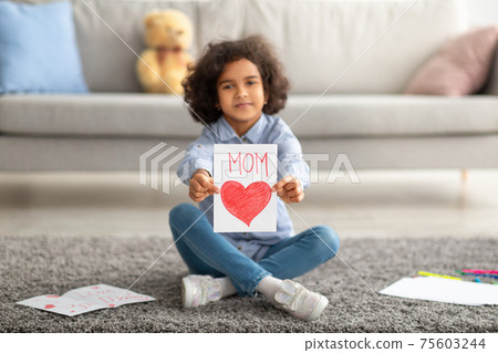 Smiling afro girl showing greeting card for mother's day 75603244