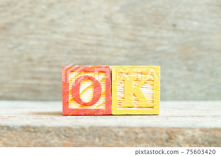 Color alphabet letter block in word OK on wood background 75603420