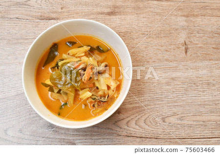 spicy boiled mussel with pineapple and lemon leaf in coconut milk curry soup on bowl spicy boiled mussel with pineapple and lemon leaf in coconut milk curry soup on bowl 75603466