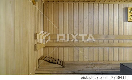 Sauna accessories are in the interior of the steam room. The interior of the sauna. Sauna from linden. 75604311