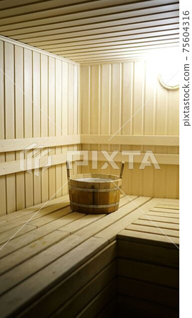 Sauna accessories are in the interior of the steam room. The interior of the sauna. Sauna from linden. Sauna accessories are in the interior of the steam room. The interior of the sauna. Sauna from linden. 75604316