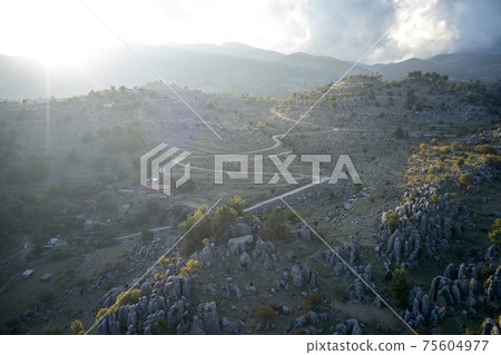 Aerial view of misty mountain valley with rock formations. 75604977