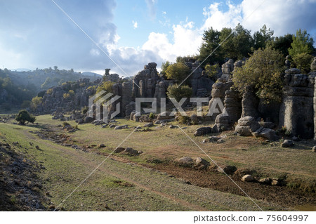 Beautiful green valley with rock formation on a summer day. Beautiful green valley with rock formation on a summer day. 75604997