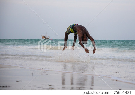 Young Attractive Muscular and Strong Athletic Black African Man at the White Sand Beach Training Body Calisthenics Young Attractive Muscular and Strong Athletic Black African Man at the White Sand Beach Training Body Calisthenics 75605421