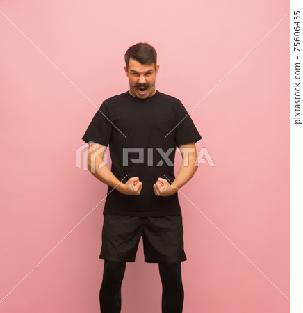 Young Caucasian man in black sports attire isolated on pink background. Young Caucasian man in black sports attire isolated on pink background. 75606435