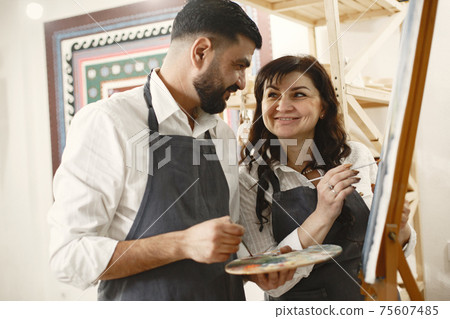 Mixed couple painting in a class Mixed couple painting in a class 75607485