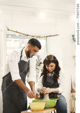 Adult mixed couple at artwork in pottery Adult mixed couple at artwork in pottery 75607580