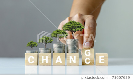 The tree on the coin and the hand flips the wooden cube by transforming it into an opportunity for personal development and financial growth. The tree on the coin and the hand flips the wooden cube by transforming it into an opportunity for personal development and financial growth. 75607629