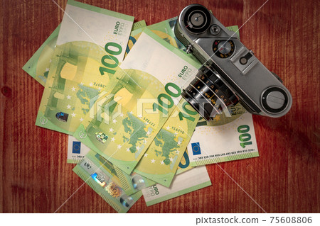 Old film camera and pile of money Old film camera and pile of money 75608806