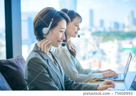 Middle operator who wears a headset in the office Middle operator who wears a headset in the office 75608993