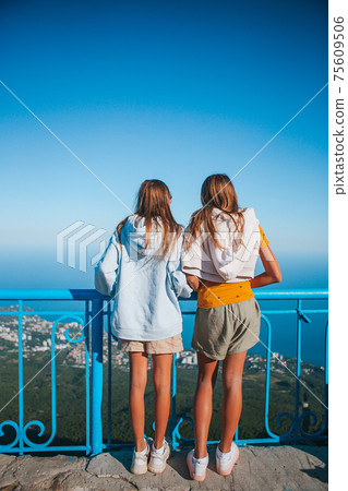Girls crossing the chasm on the rope bridge. Girls crossing the chasm on the rope bridge. 75609506