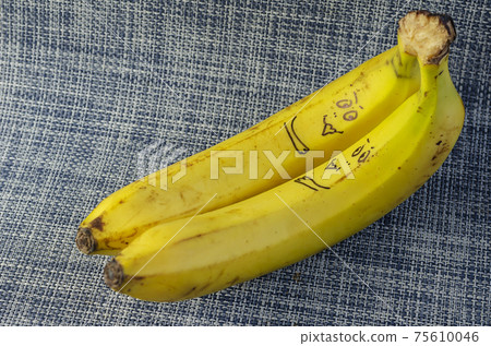 Lovers bananas on white and blue background. Two ripe bananas with drawn smiley faces. Love, relationships. Selective focus. Lovers bananas on white and blue background. Two ripe bananas with drawn smiley faces. Love, relationships. Selective focus. 75610046