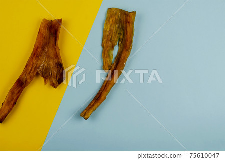Natural dental treats for dogs. Chew Treats. Dried beef tendons on a two-color background. Flat Lay. Natural dental treats for dogs. Chew Treats. Dried beef tendons on a two-color background. Flat Lay. 75610047