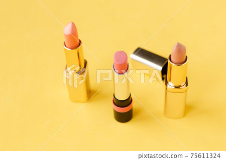 Set of pink lipsticks on bright yellow background. Beauty and cosmetics background. Decorative cosmetics, makeup, women's lipstick, beauty brand, product design Set of pink lipsticks on bright yellow background. Beauty and cosmetics background. Decorative cosmetics, makeup, women's lipstick, beauty brand, product design 75611324