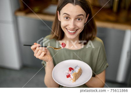 Woman enjoys a sweet dessert at home Woman enjoys a sweet dessert at home 75611866