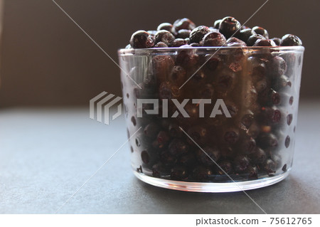 blueberries or blackcurrants on a gray black background with a place for text and copyspace view from the side 75612765