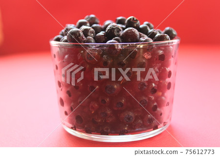 berry still life blueberries or currants in a glass on a red background with a place for text and a copyspace view from the side berry still life blueberries or currants in a glass on a red background with a place for text and a copyspace view from the side 75612773