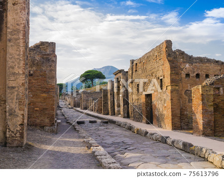 Stunning alley in the ancient city of Pompeii with ruins of buildings and the volcano Vesuvius in the background, Naples, Italy Stunning alley in the ancient city of Pompeii with ruins of buildings and the volcano Vesuvius in the background, Naples, Italy 75613796