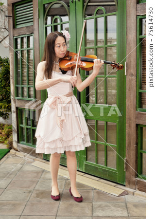 A woman playing a violin 75614730