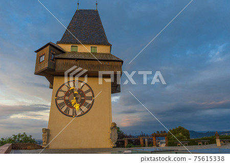 The famous clock tower (Grazer Uhrturm) and gardens on Shlossberg hill before sunrise,in Graz, Styria region, Austria The famous clock tower (Grazer Uhrturm) and gardens on Shlossberg hill before sunrise,in Graz, Styria region, Austria 75615338