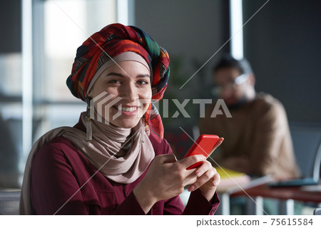 Muslim businesswoman with mobile phone Muslim businesswoman with mobile phone 75615584