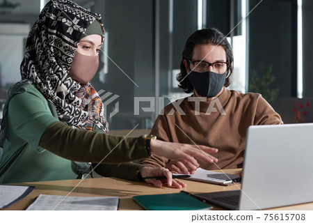 Muslim woman in mask sitting at meeting 75615708