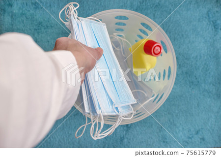 Man hands throwing medical masks in the trash, end of quarantine and disease coronavirus COVID-19 concept. Selective focus Man hands throwing medical masks in the trash, end of quarantine and disease coronavirus COVID-19 concept. Selective focus 75615779