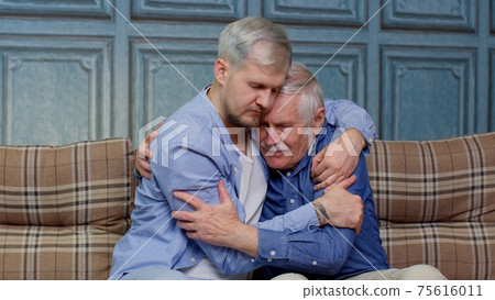 Adult man son hugging and consoling sadness old age father with love, mental health, social problems 75616011