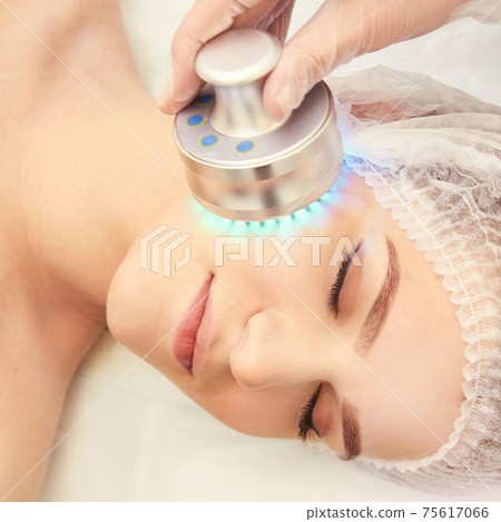Light infrared therapy. Cosmetology head procedure. Beauty woman face. Cosmetic salon device. Facial skin rejuvenation Light infrared therapy. Cosmetology head procedure. Beauty woman face. Cosmetic salon device. Facial skin rejuvenation 75617066