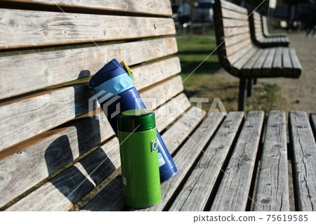 A water bottle on a park bench A water bottle on a park bench 75619585