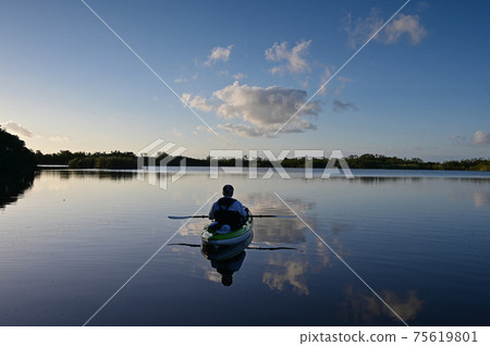 Active senior kayaking on Nine Mike Pond in Everglades National Park, Florida. 75619801