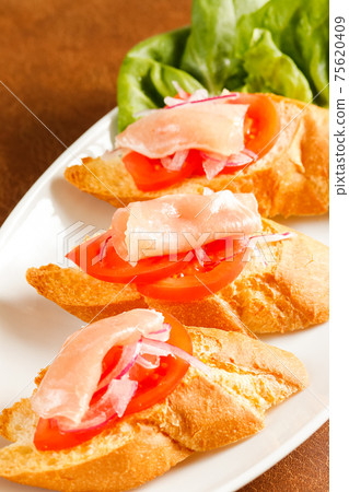 Bruschetta with prosciutto and tomato 75620409