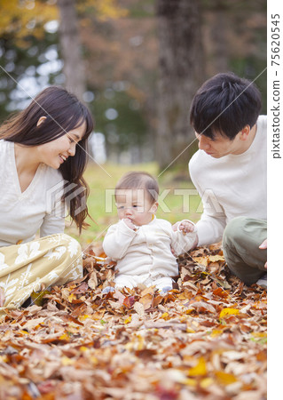 Family playing in the autumn park 75620545