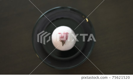 A picture of a cherry blossom bun on a black plate from above 75621520