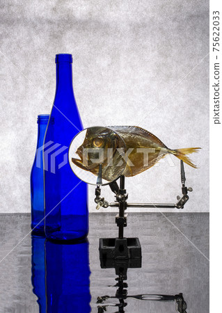 Still life with blue bottles and sea fish with magnifying glass 75622033