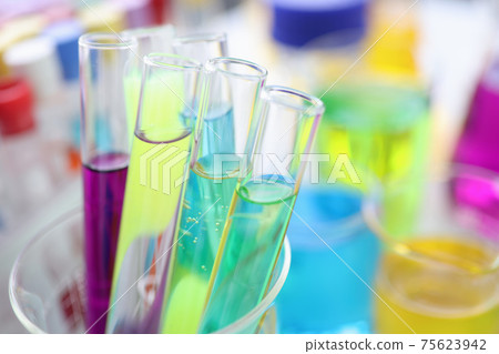Chemical test tubes with multi-colored liquid on desktop in laboratory 75623942
