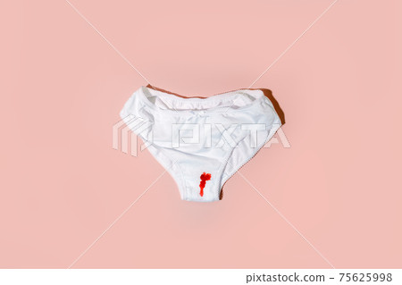White cotton panties for women with traces of fresh red blood. Concept of menstruation, female shame, taboo, daily hygiene, critical days, premenstrual syndrome White cotton panties for women with traces of fresh red blood. Concept of menstruation, female shame, taboo, daily hygiene, critical days, premenstrual syndrome 75625998