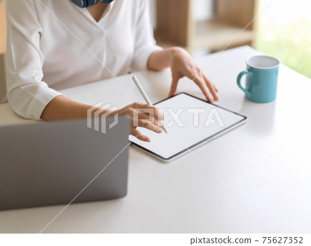 Female working with mock up digital tablet on white desk in home office room 75627352