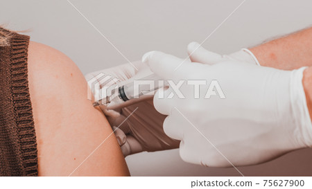 The laboratory assistant injects an antiviral into the patients hand, carrying out the procedure close-up. The laboratory assistant injects an antiviral into the patients hand, carrying out the procedure close-up. 75627900
