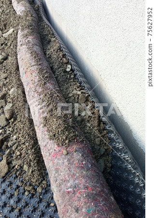 Groundwater drainage. Workers carry out drainage works to drain the water around the house. 75627952