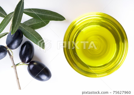 a glass bowl full of olive oil with olive brunch, made in Puglia, Salento a glass bowl full of olive oil with olive brunch, made in Puglia, Salento 75627960