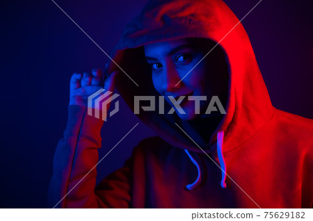 Portrait of a beautiful young woman in a sweatshirt with a hood in neon light Portrait of a beautiful young woman in a sweatshirt with a hood in neon light 75629182