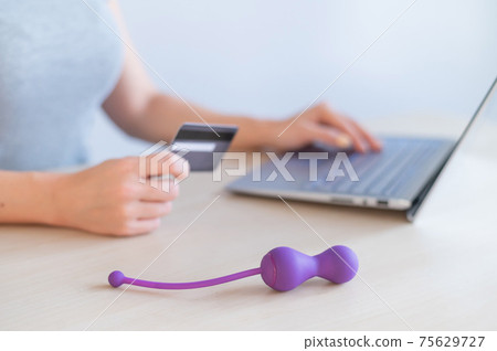 A woman is shopping online in a sex shop. The girl is looking for satisfaction on the Internet 75629727
