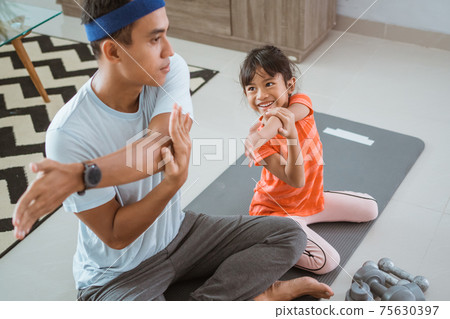 father and daugther exercising together at home 75630397