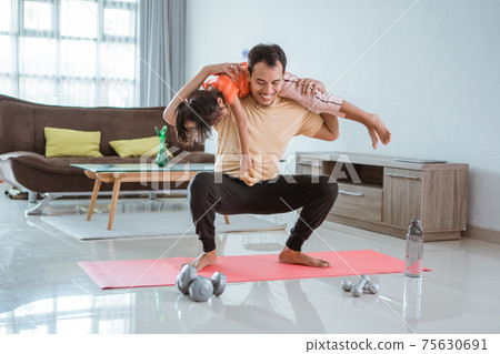 man doing squat while carrying his daughter man doing squat while carrying his daughter 75630691