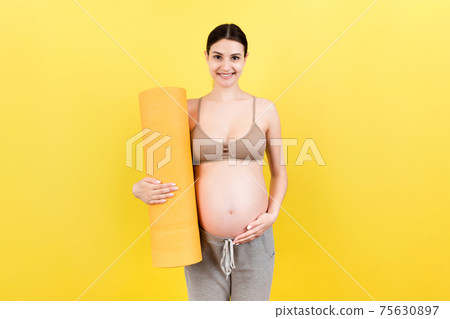Pregnant Girl Holding Yoga Mat Standing Over Colored Background. Studio Shot, Free Space For Design Pregnant Girl Holding Yoga Mat Standing Over Colored Background. Studio Shot, Free Space For Design 75630897