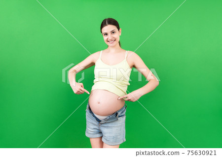 Young beautiful teenager girl pregnant expecting baby over isolated colored background smiling showing big belly Young beautiful teenager girl pregnant expecting baby over isolated colored background smiling showing big belly 75630921