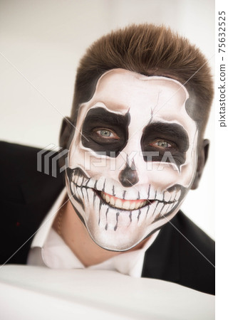 Man with make-up Halloween. Drawing a vampire, skeleton Man with make-up Halloween. Drawing a vampire, skeleton 75632525