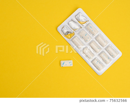 rectangular pieces of gum in a blister pack on a yellow background 75632566